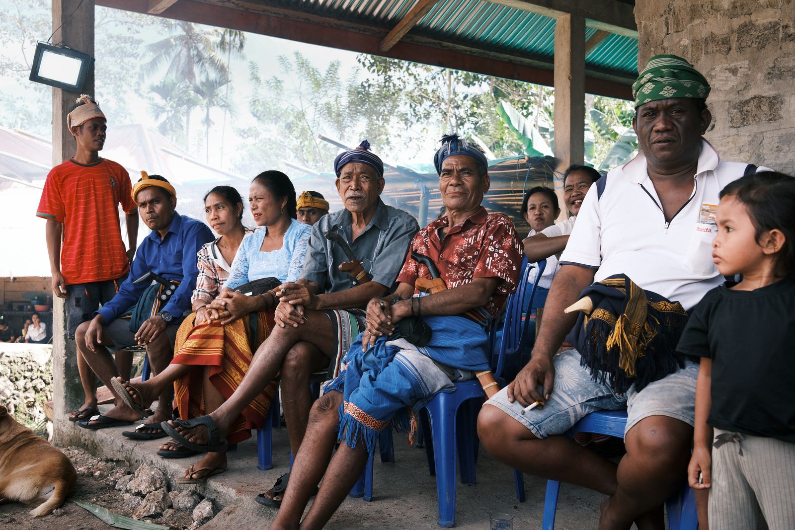 Families seated together in the shade of a pavilion