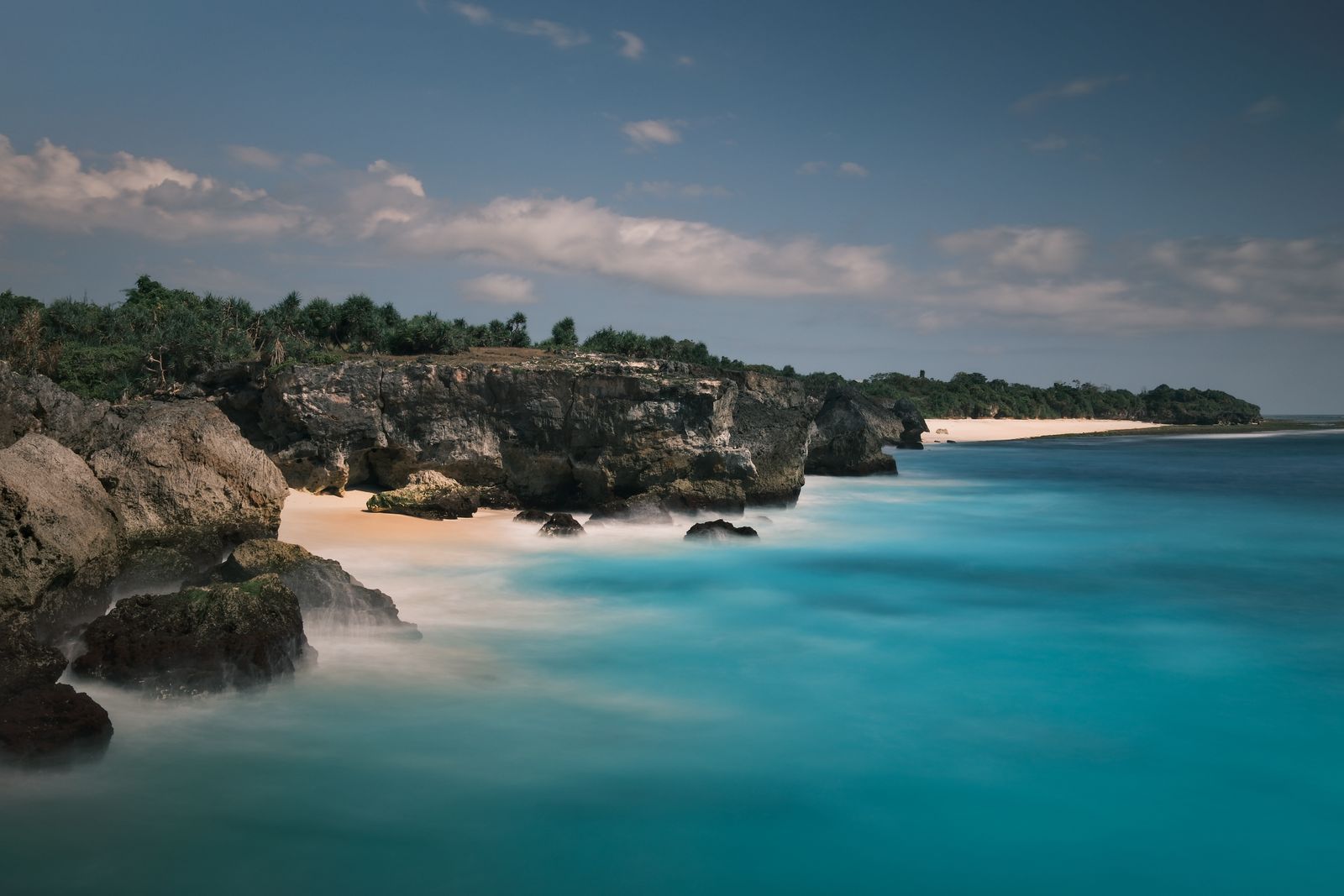 Turquoise bay ringed by rock and forest